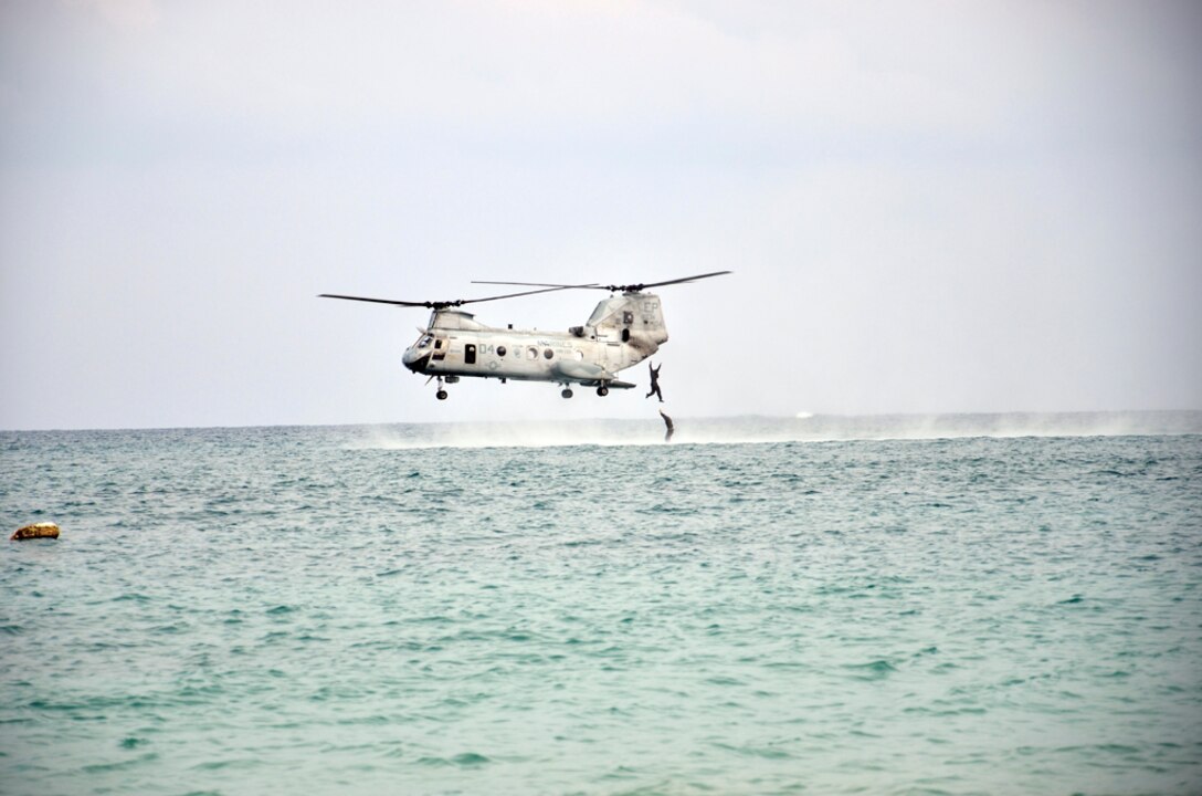 Two Marines with 3rd Reconnaissance Battalion, 3rd Marine Division, III Marine Expeditionary Force, exit a CH-46E Sea Knight helicopter 10 feet above the water’s surface during helocast operations training at Camp Schwab Nov. 23.
